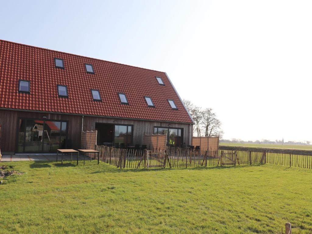 a barn with a red roof and a grass field at Luxury waterfront villa in Leons
