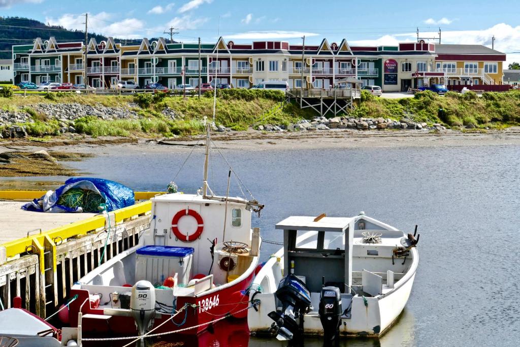 two boats docked at a dock in the water at Ocean View Hotel in Rocky Harbour