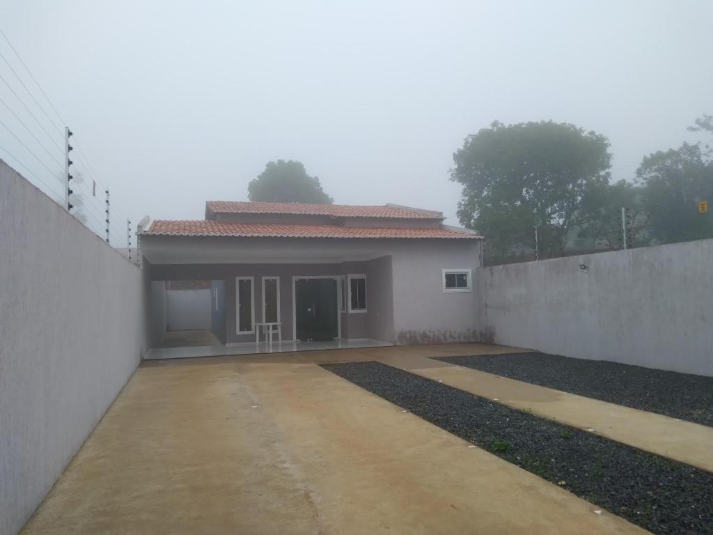 a small white house with a fence next to it at Casa Selma Ubajara in Ubajara