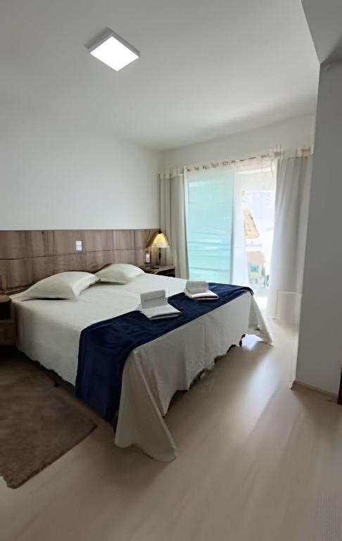 a bedroom with a large bed with a blue blanket at Apto Copo Leite|3Q c|Sacada,Churrasqueira,na Aven in Piratuba