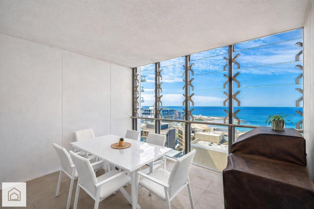 a dining room with a table and chairs and the ocean at 1011 - First Light 2BR with Ocean Views - Prime Location in Newcastle