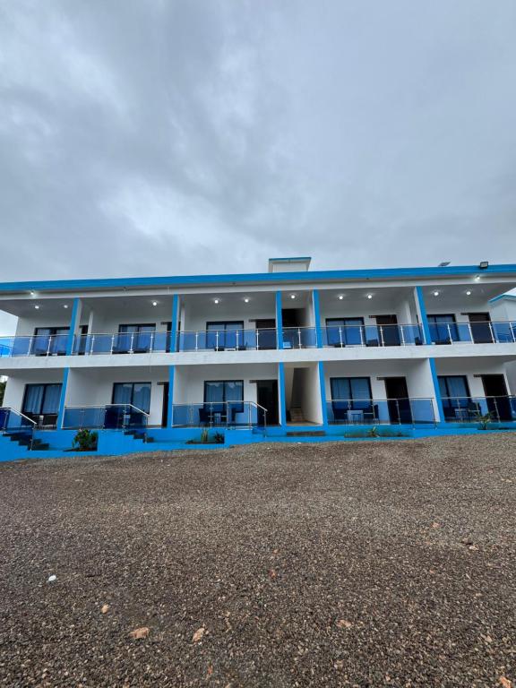 an apartment building with blue balconies on a beach at Hotel Rincón Samaná in Las Galeras
