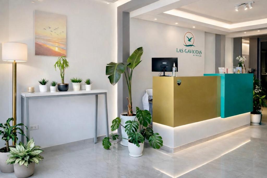 a lobby with potted plants and a reception desk at LAS GAVIOTAS DE PARACAS in Paracas