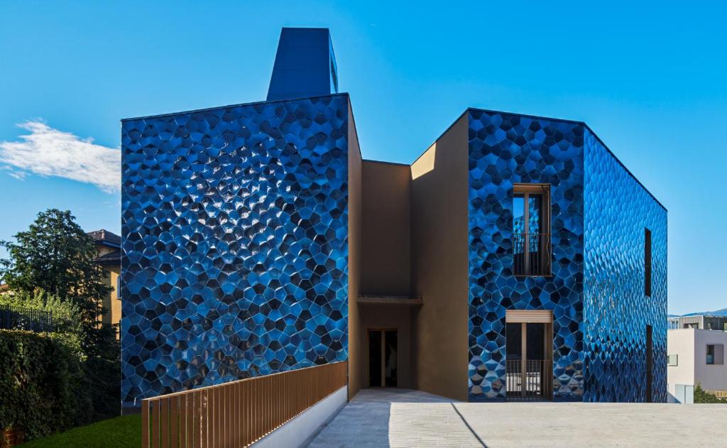 a building with blue tiles on the side at Design Apartment Archea Terrazza sul Lago Maggiore in Laveno-Mombello