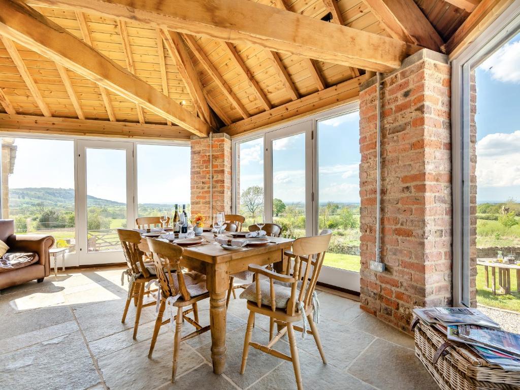 a dining room with a table and chairs and windows at The Gin Gang in Whorlton