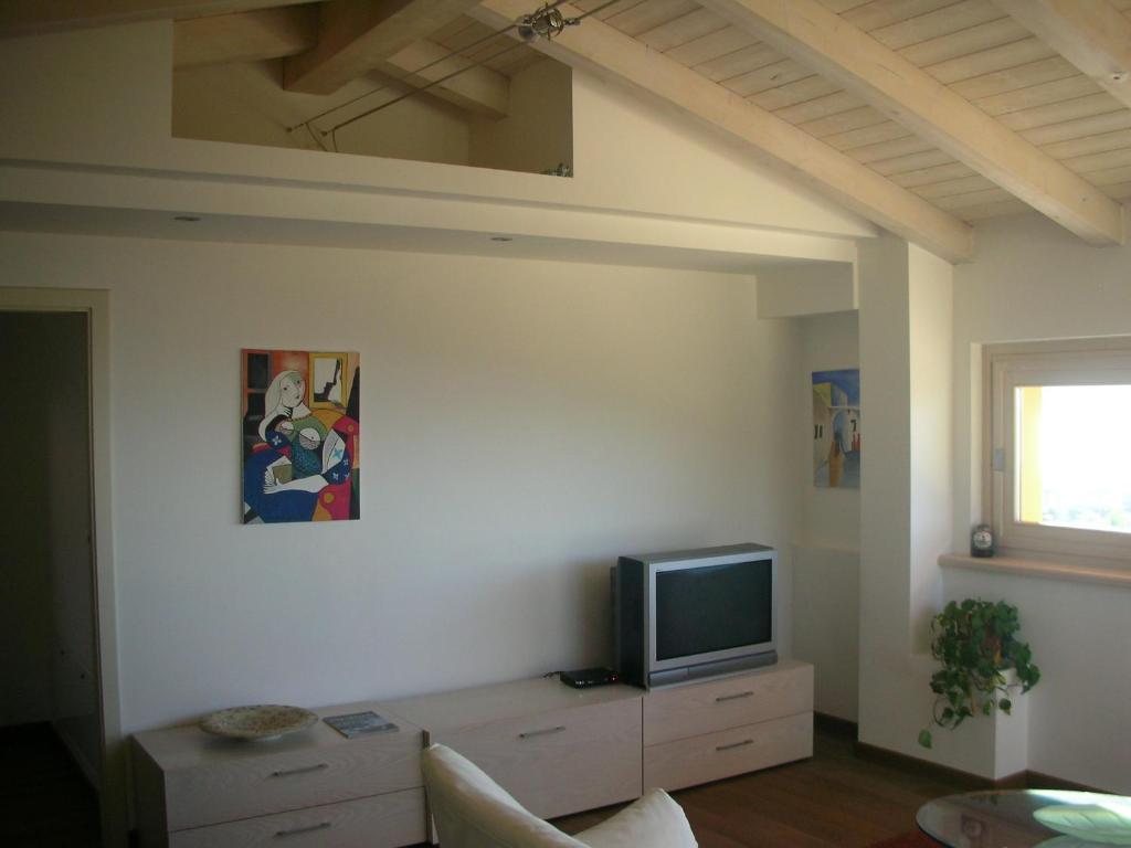 salon z telewizorem na białej ścianie w obiekcie Villa Susina Casa Vacanze w mieście Toscolano Maderno