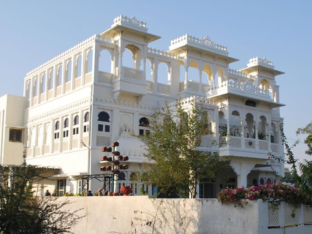 een groot wit gebouw met een balkon bij Gadh Ganesh Homestay in Udaipur