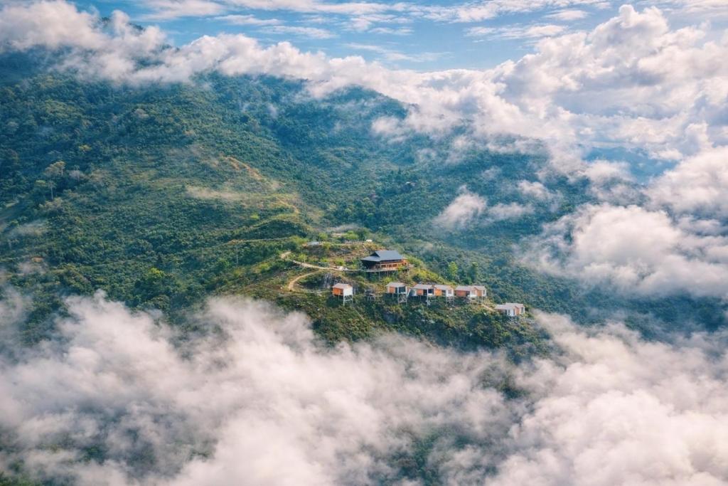 a house on top of a hill in the clouds at Háng Đồng Ecolodge in Bắc Yên