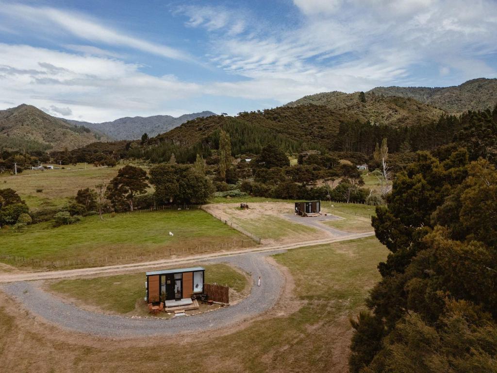 an aerial view of a house in a field with a winding road at Omoho Stream X by Tiny Away in Kennedys Bay