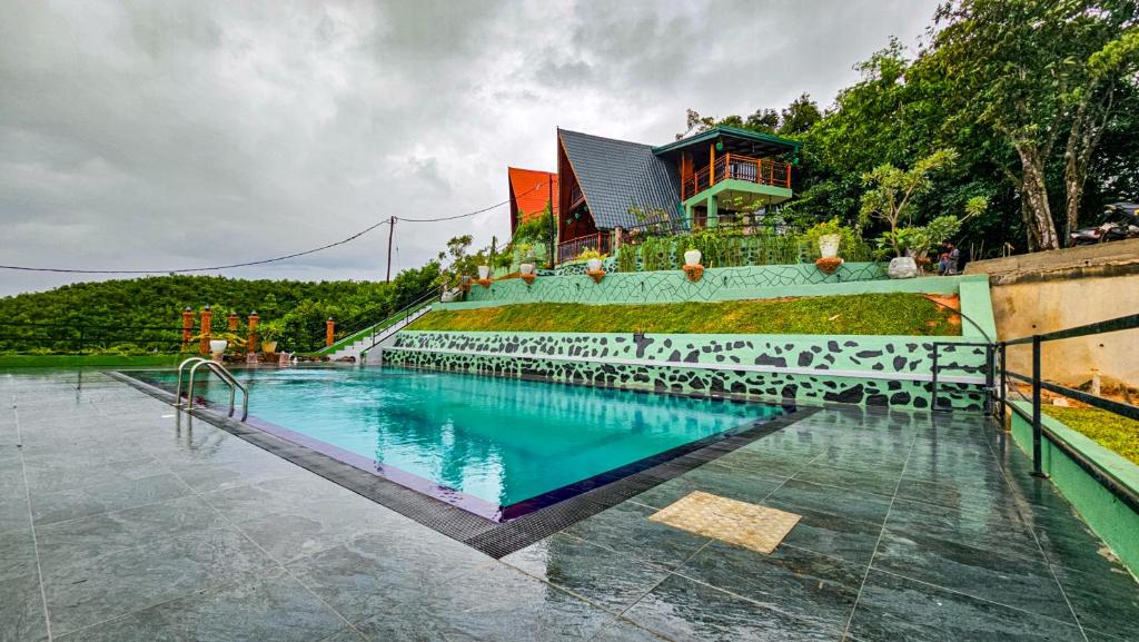 a swimming pool in front of a house at Cinnamon Crown in Matara