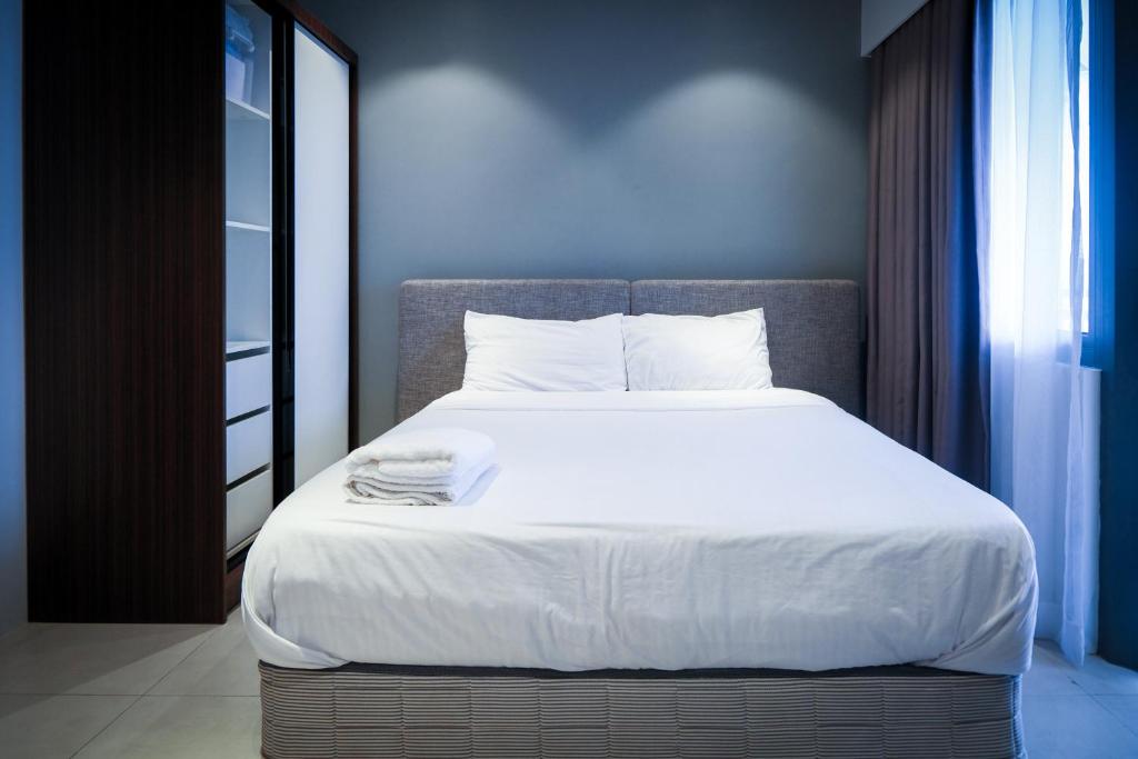 a bedroom with a large bed with white sheets at Top Floor Studio Non-Resort Unit Tambuli Tower D in Maribago