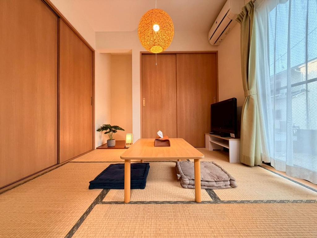 a living room with a table and a tv at ura tomari in Okayama