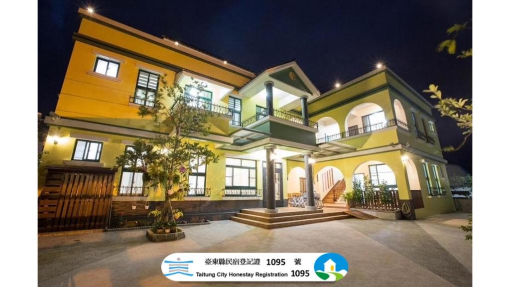 a large yellow and white house at night at 春夏秋冬民宿 - 臺東縣民宿1095號 in Guanshan