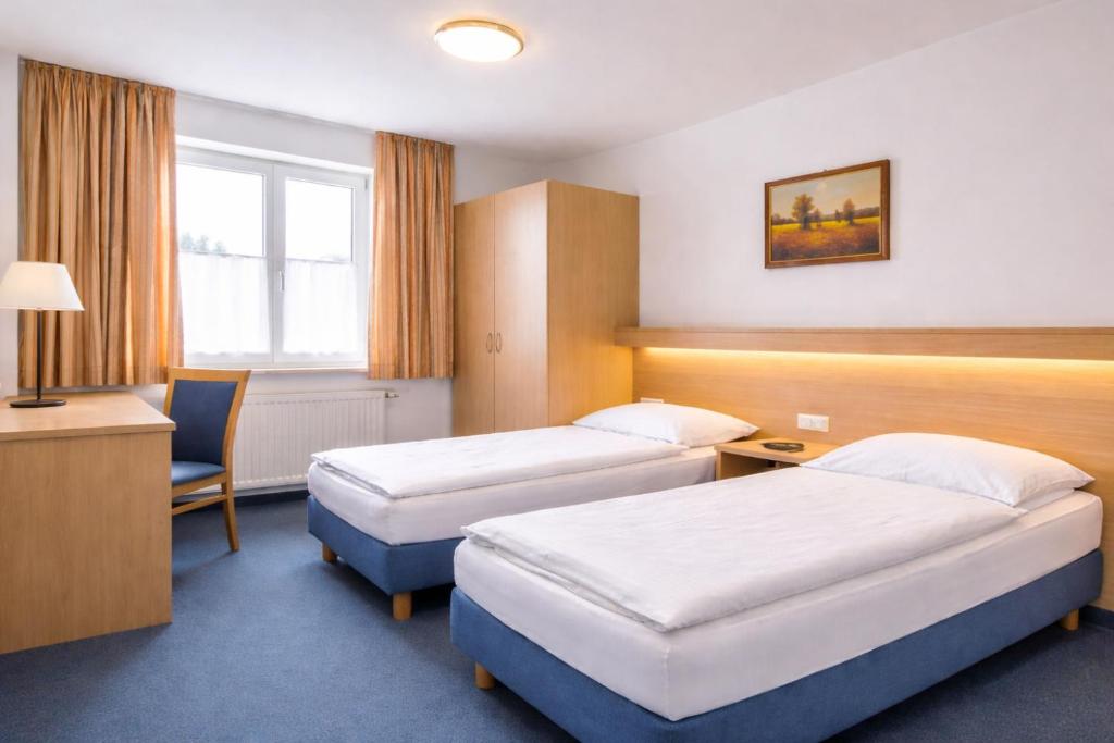 a hotel room with two beds and a chair at Hotel Wendelstein München City in Munich