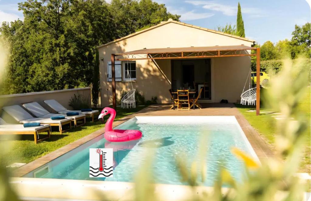 a swimming pool with a pink flamingo in a backyard at La Villa Sable en Provence in Saint-Saturnin-lès-Apt