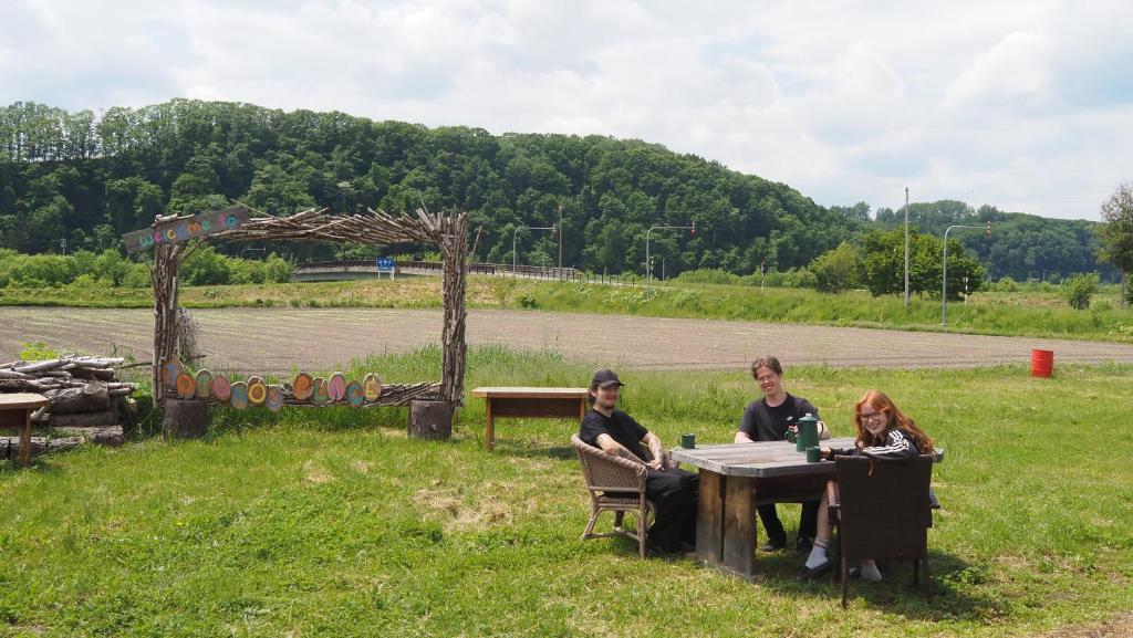 three women sitting at a table in a field at TOTONOU Place in Asahikawa