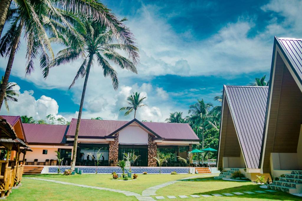 a building with palm trees in front of it at H&P Beach Resort in Pandan