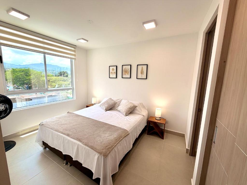 a bedroom with a bed and a large window at Apartamento en Villeta in Villeta