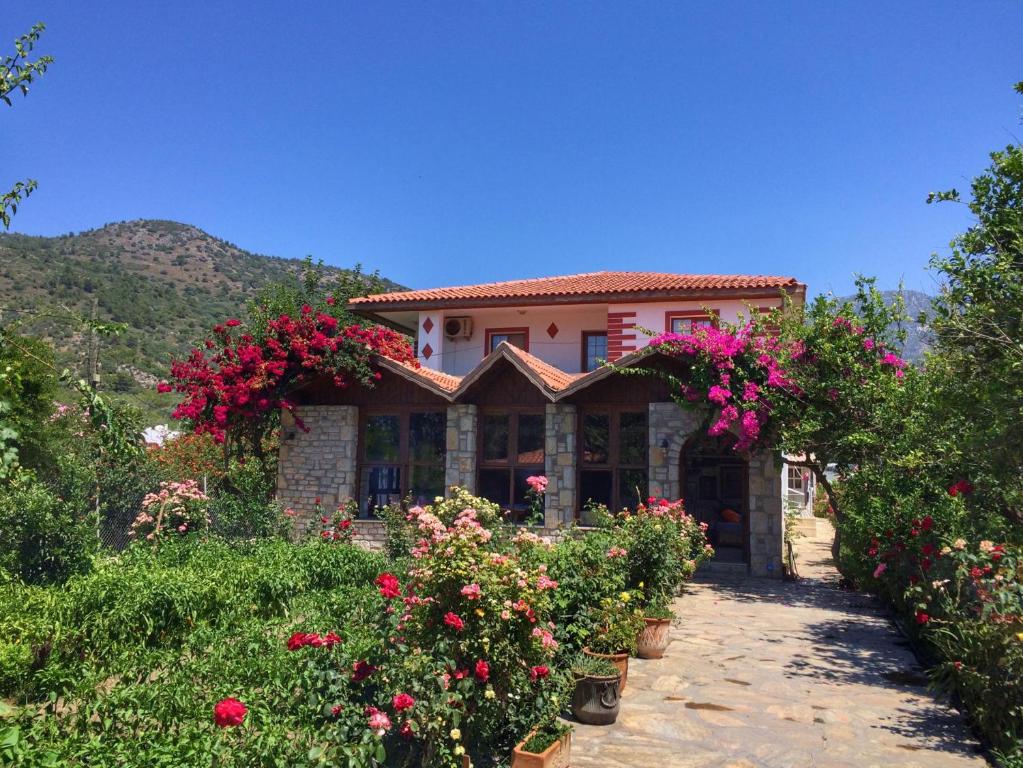 a house with flowers in front of it at Melinda Pension & Restaurant in Mesudiye
