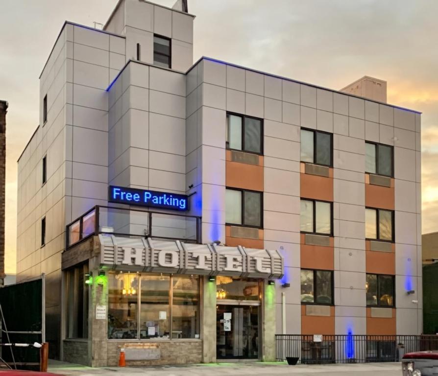 a white building with a free parking sign on it at Umbrella Hotel Brooklyn - Newly Renovated in Brooklyn