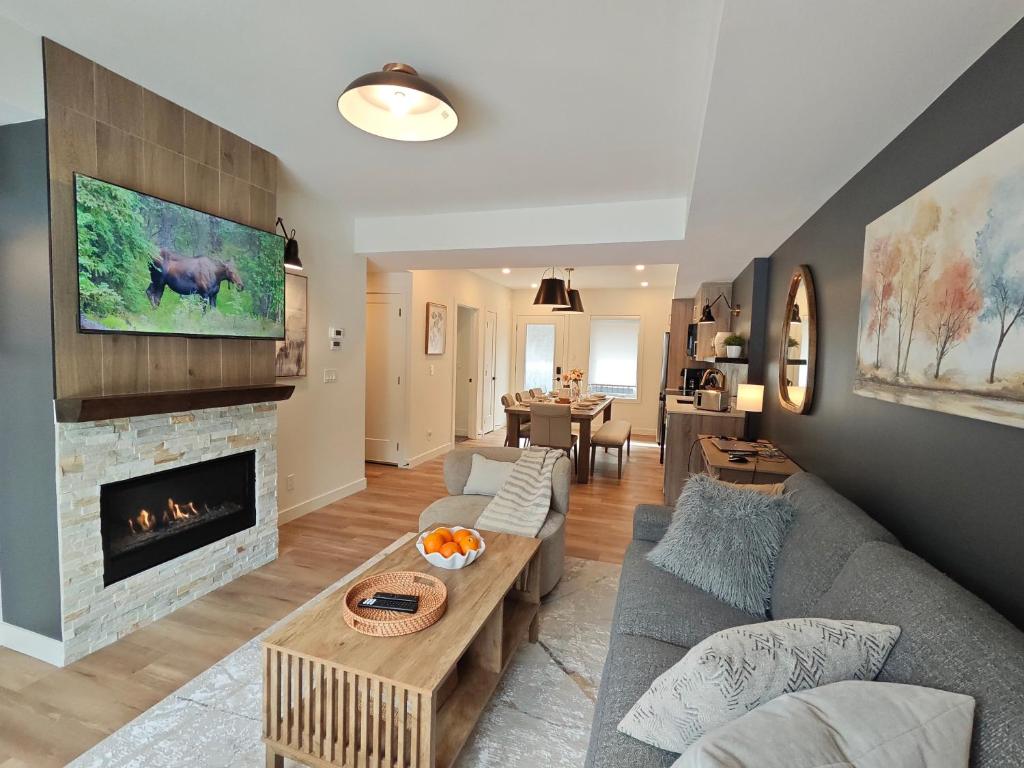 a living room with a couch and a fireplace at New Luxury MountainView Downtown2B2B RooftopHottub in Canmore