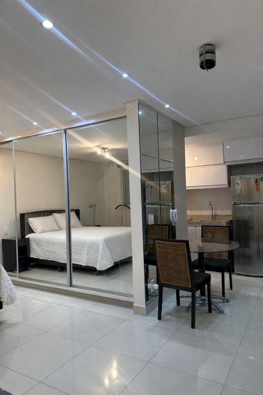 a bedroom with a bed and a desk and a chair at Flat Lounge 22 Setor Oeste in Goiânia