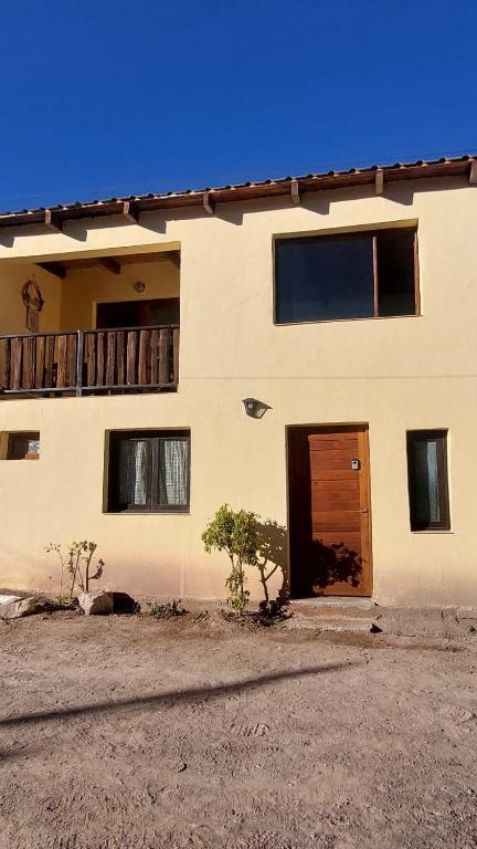 a white building with a door and a balcony at Dúplex céntrico LAS SOFIAS - PURMAMARCA in Purmamarca