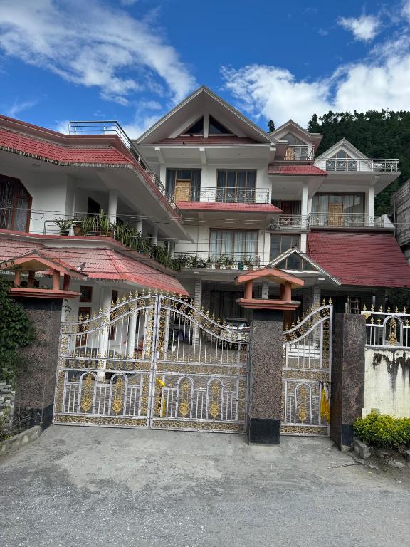 a large house with a gate in front of it at KmK Homestay in Rupa
