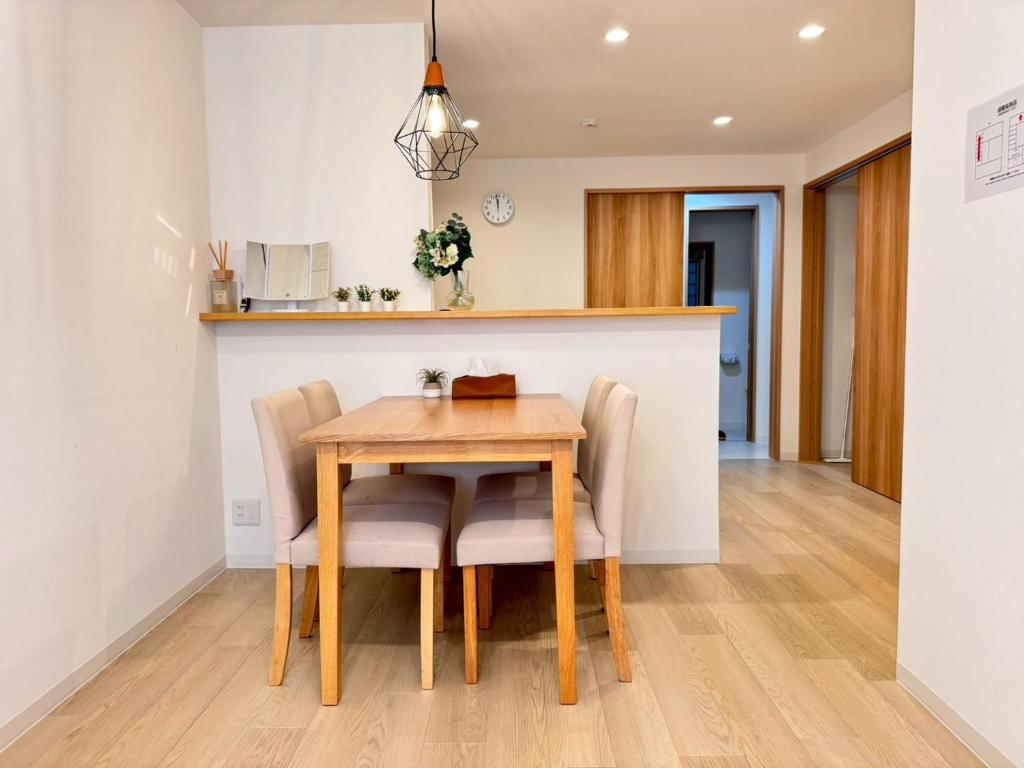 a kitchen and dining room with a wooden table and chairs at ura BETTEi 別邸 in Okayama