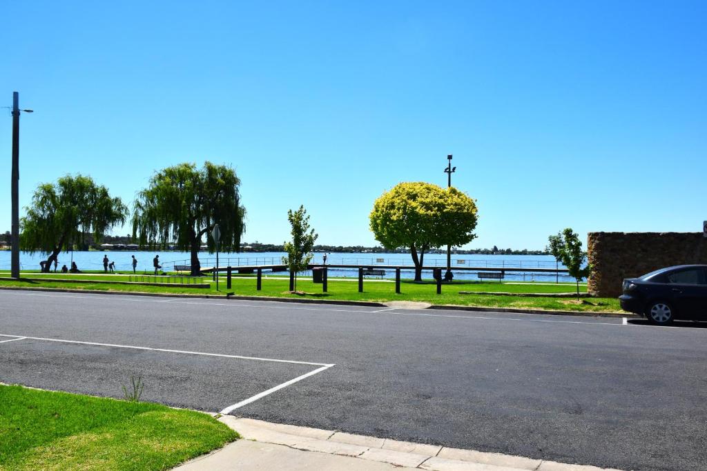 a car parked on the side of a road near a body of water at Bank's Place in Yarrawonga