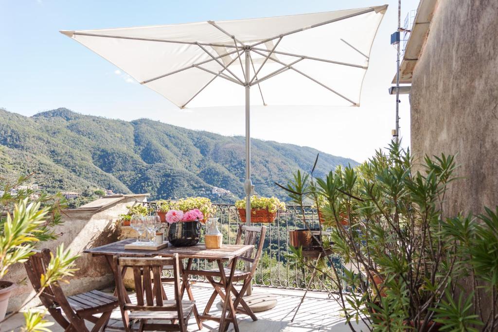 een patio met een tafel en een parasol bij Casa degli Olivi in Levanto