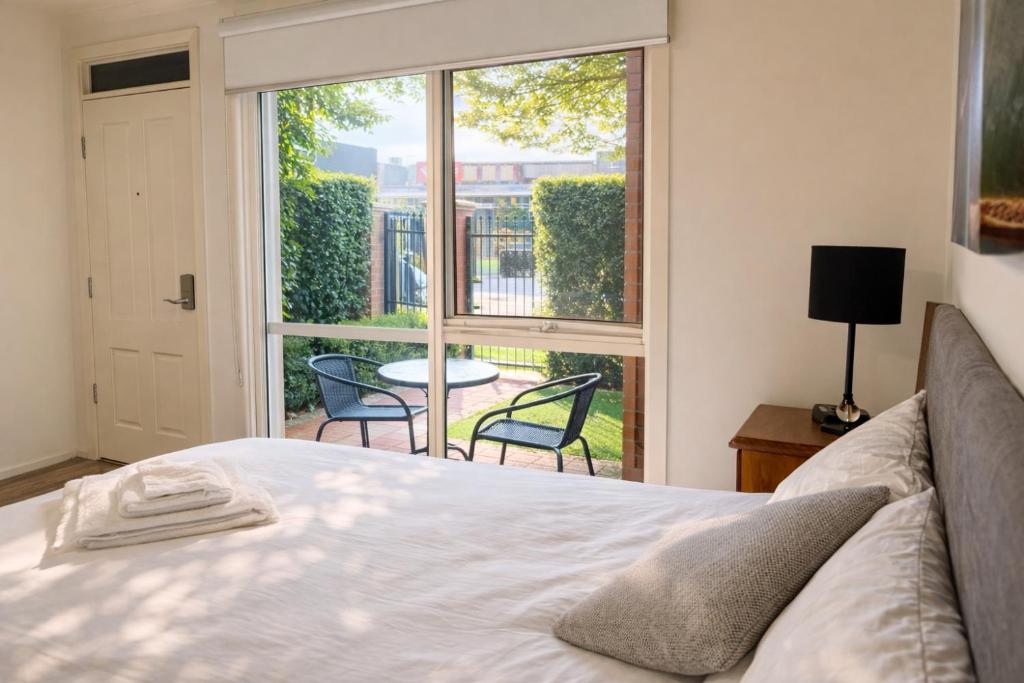 a bedroom with a bed and a large window at Box Hill Studio Apartment 2 in Box Hill