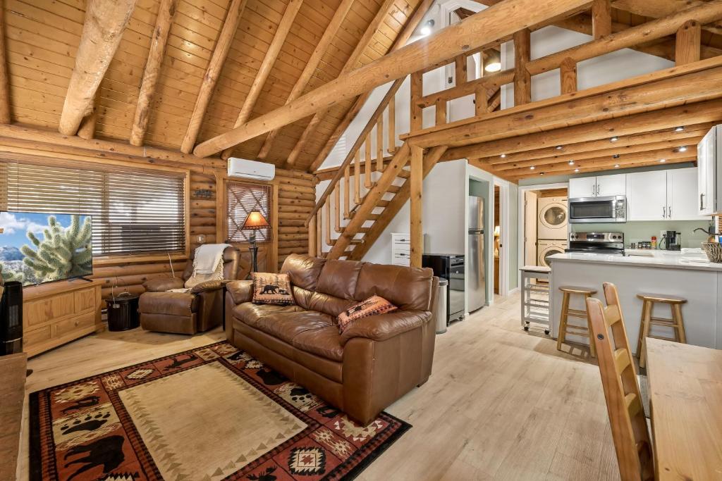 a living room with a leather couch and a kitchen at Forest Hideaway Near Sedona in Munds Park