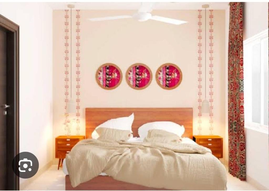 a bedroom with a bed and three plates on the wall at Alwar stay in Alwar