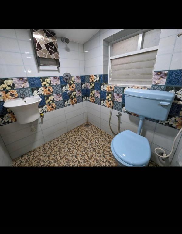 a bathroom with a blue toilet and a sink at Sanoraaa Resort in Dabolim