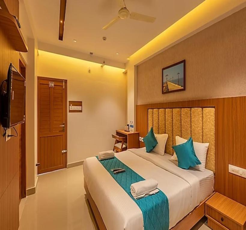 a bedroom with a large bed and a television at Hotel Morya Suites IGI Airport in New Delhi