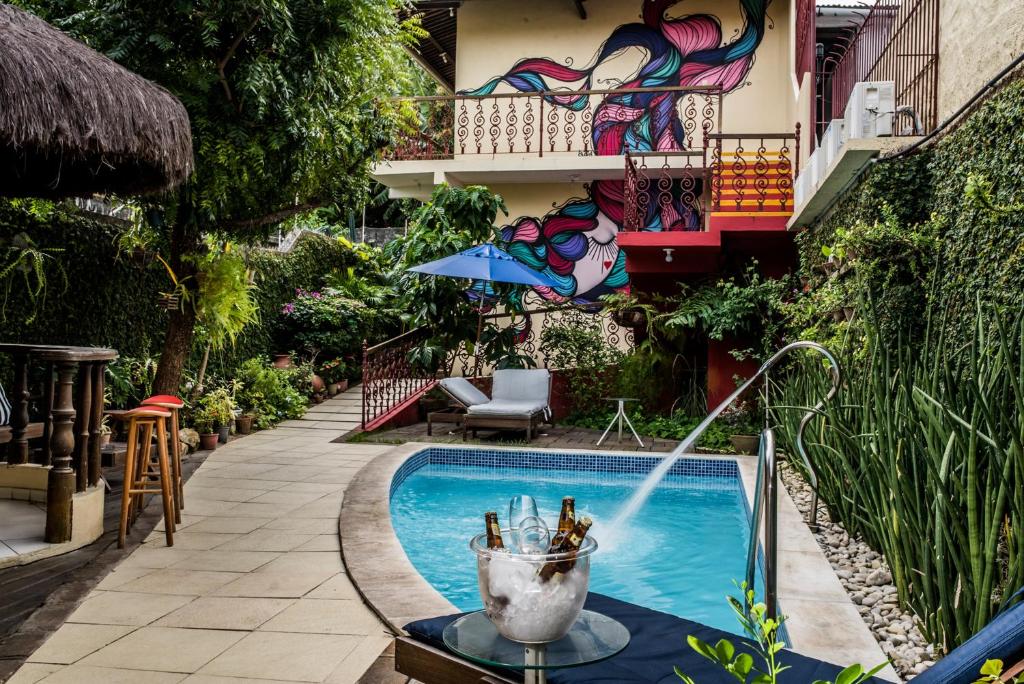 a pool with a fountain in front of a building at Pousada Baobá in Olinda