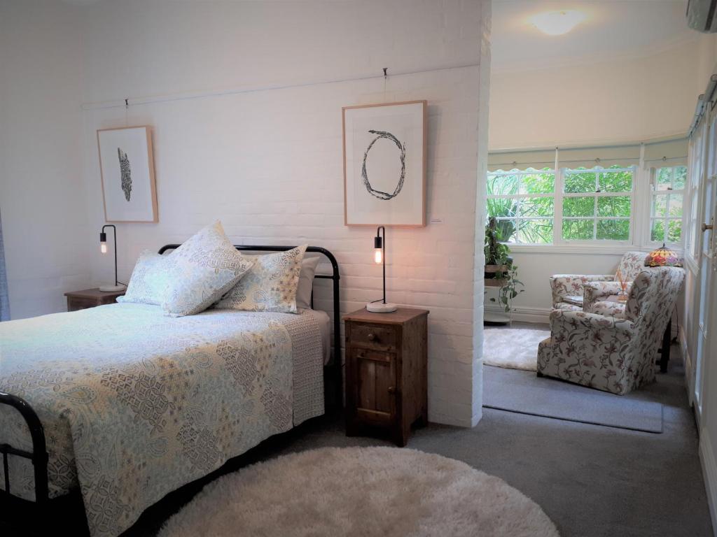 a bedroom with a bed and a chair at The old Chiltern bank BnB in Chiltern