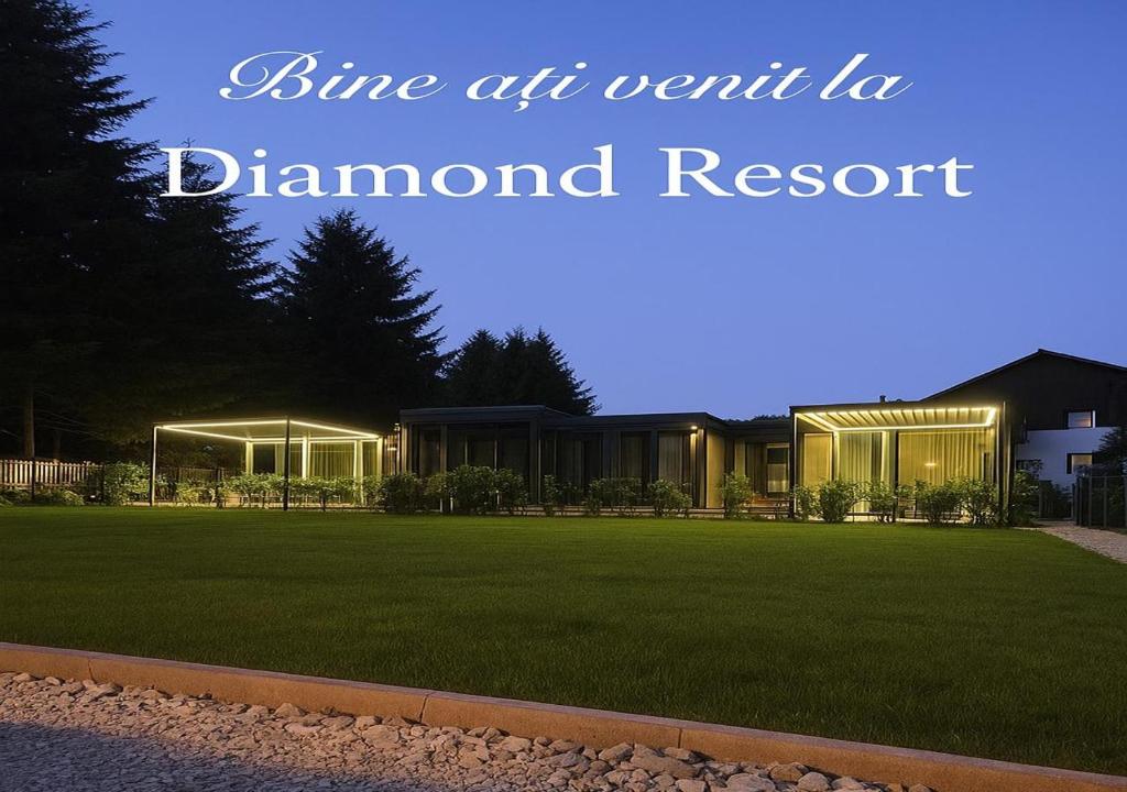 a house with lights on a lawn at night at Diamond Resort Busteni in Buşteni
