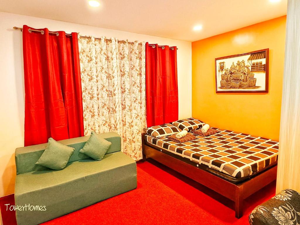 a bedroom with a bed and a couch and red curtains at 2B-03 Condo Staycation at Megatower 1 in Baguio