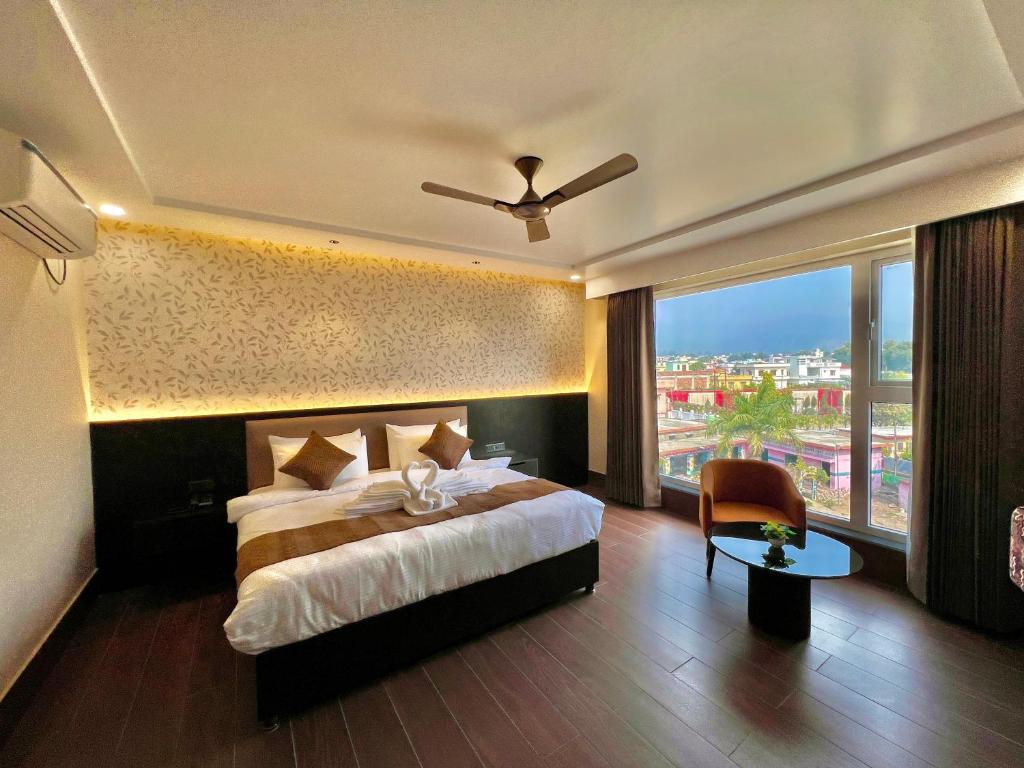 a hotel room with a bed and a large window at Hotel Mango Groves in Kotdwāra