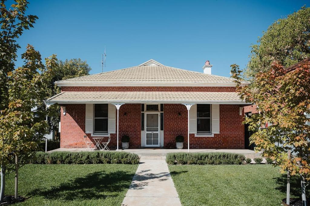 a red brick house with a pathway in front of it at Blacksmith House on Main in Tocumwal