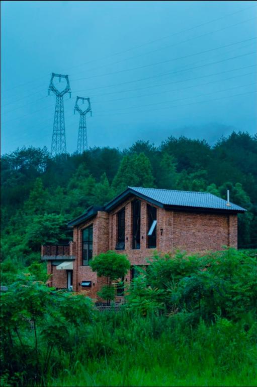 a brick house with two windmills in the background at 伴山一墅 in Chaoyang