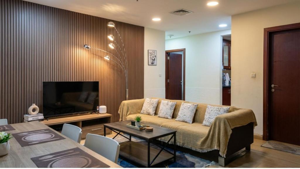 a living room with a couch and a television at Devine Holidays JBR in Dubai