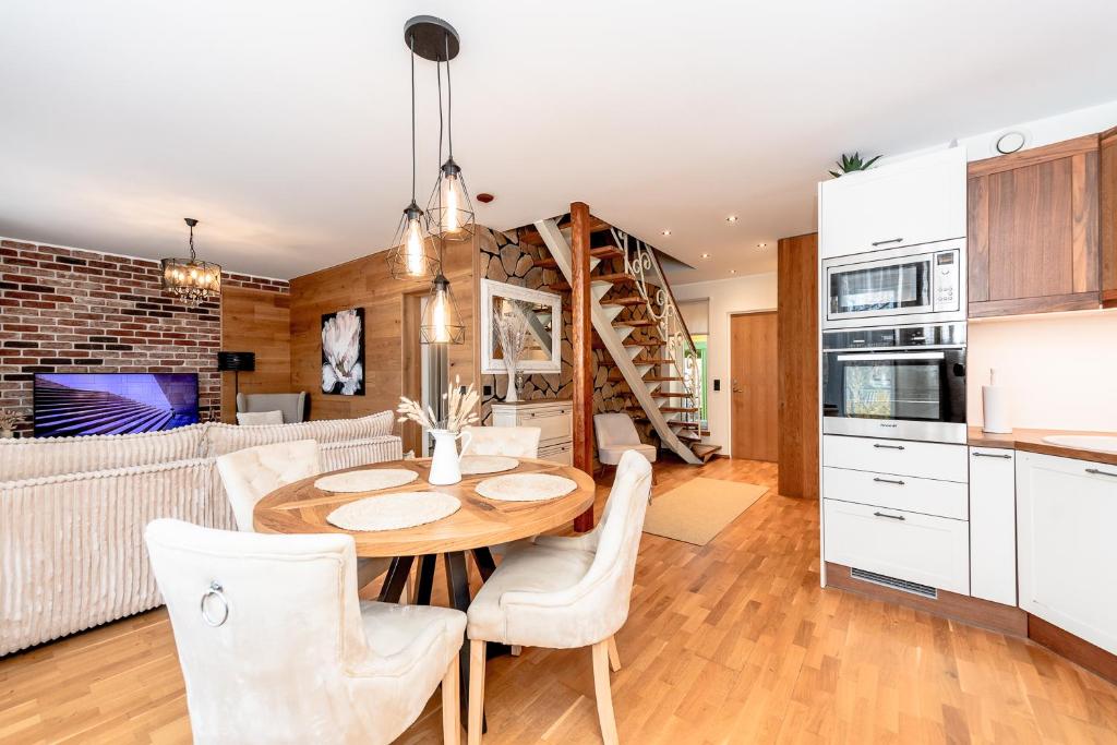a kitchen and dining room with a table and chairs at Sunset Stay Pärnu in Pärnu