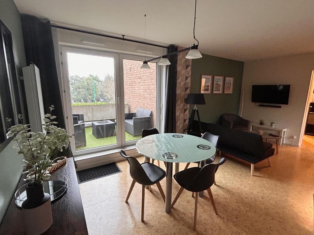 a living room with a table and chairs at Lestandardgravelines in Gravelines