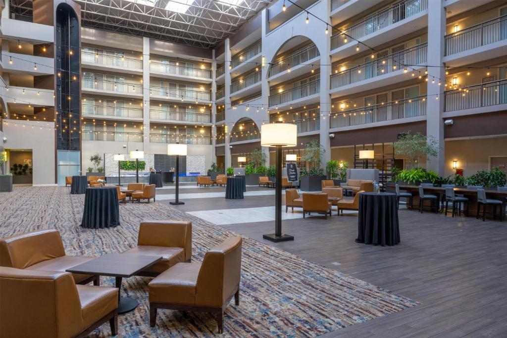 an empty lobby of a hotel with tables and chairs at Embassy Suites by Hilton Seattle Bellevue in Bellevue