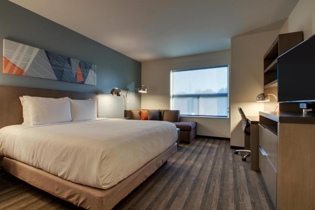a hotel room with a bed and a couch at Hyatt House Oak Brook in Oak Brook