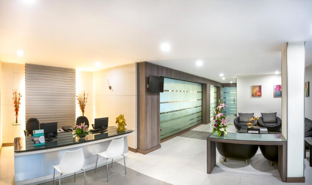 a lobby with a reception desk and chairs at The Lotus Apartment Hotel, Venkatraman Street in Chennai