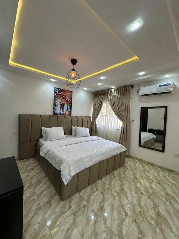 a bedroom with a large bed and a mirror at Q2Shortlet Apartment in Isheri-Olofin